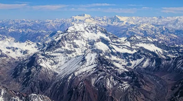 Aconcagua's rocky snow-streaked south side under a blue sky