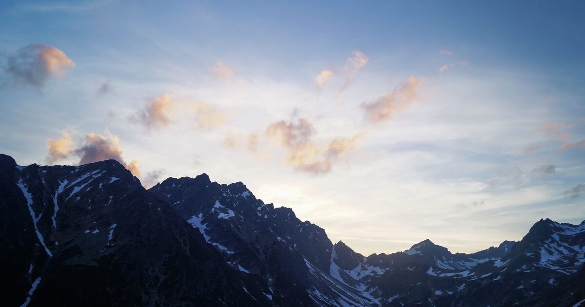 A jagged alpine ridgeline silhouetted at dusk