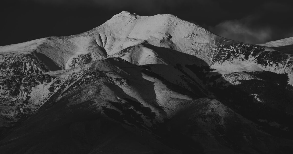 A snow-lit mountain peak in dramatic light