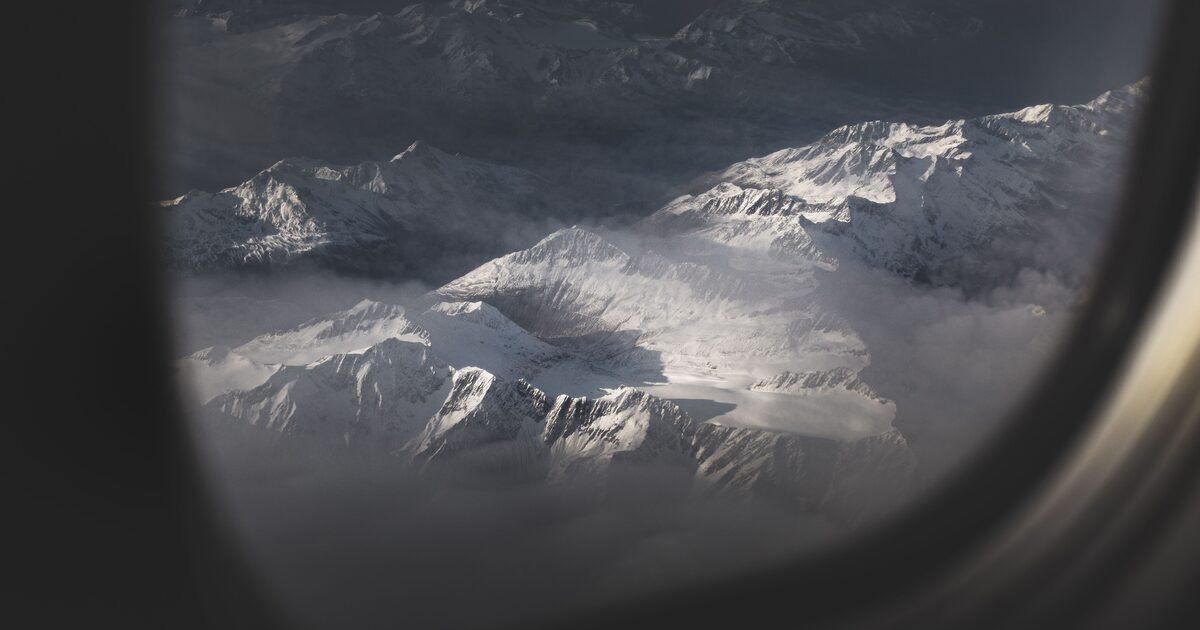 Snow-covered mountains seen through an airplane window