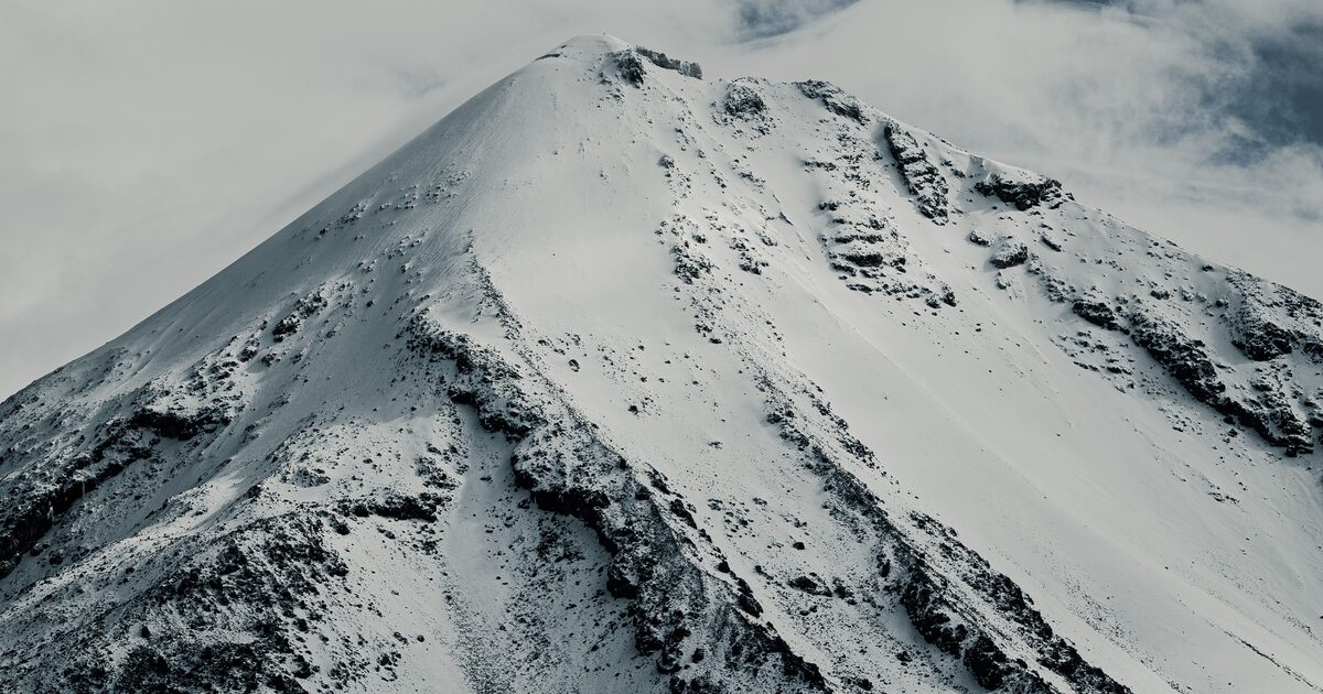A snow-covered summit reaching into the clouds